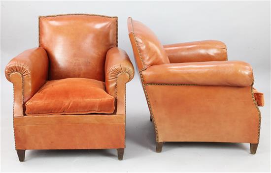 A pair of 1940s French russet leather club armchairs, W.2ft 7in. D.2ft 10in. H.2ft 8in.